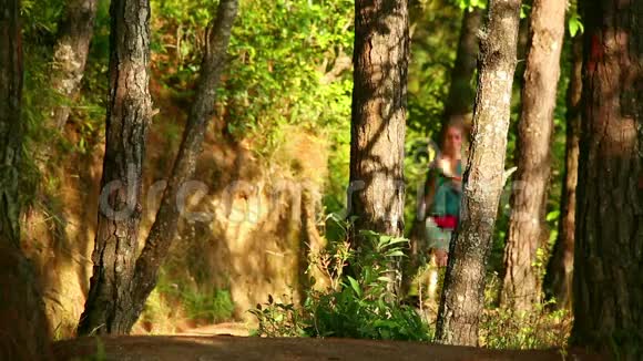 女孩沿着森林中的狭窄小径奔跑视频的预览图