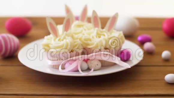 桌上有复活节彩蛋和糖果的纸杯蛋糕视频的预览图