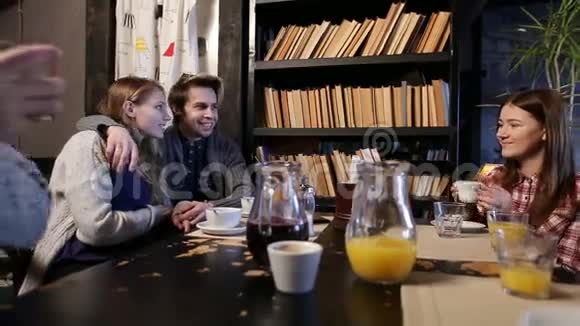 一群年轻朋友一起在咖啡馆里享受视频的预览图