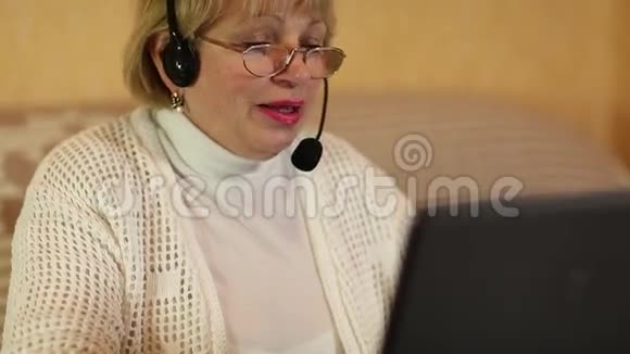带麦克风耳机的女士通过电脑与顾客交谈视频的预览图