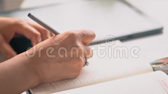 女人的手在笔记本上书写视频的预览图