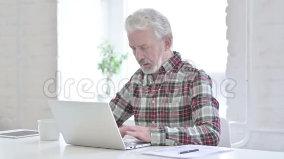 在笔记本电脑上工作的临时老人视频的预览图