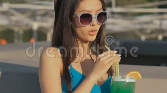 年轻的亚洲时尚女性在海滩酒吧喝鸡尾酒视频的预览图