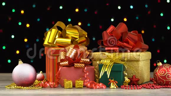 漂亮的圣诞礼品盒和装饰放在木地板上黑色背景上有五颜六色的闪光花环视频的预览图