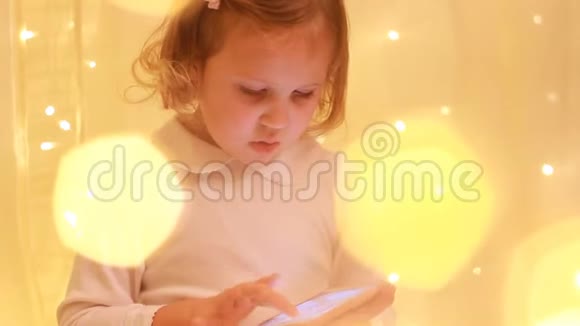 小女孩看手机屏幕玩下载的应用程序视频的预览图