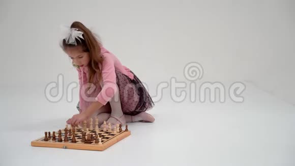 小女孩在下棋在白色背景上视频的预览图