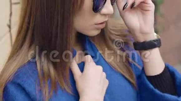 戴太阳镜的年轻女子在室外看相机视频的预览图