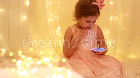 小女孩看手机屏幕玩下载的应用程序视频的预览图