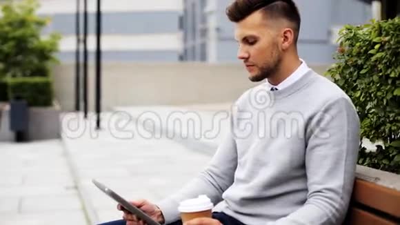 有平板电脑和咖啡的人在城市街凳上视频的预览图