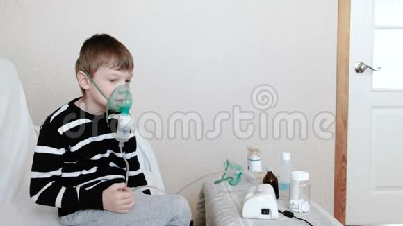 使用雾化器和吸入器进行治疗男孩通过吸入器面罩吸入侧视图视频的预览图