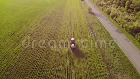 日落时用喷雾器除草剂和杀虫剂喷洒农用拖拉机的空中景观农业机械视频的预览图