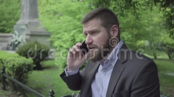 商人用智能手机说话户外视频的预览图