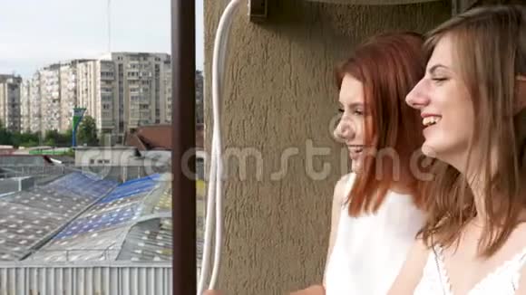 两个女人在阳台上谈笑风生视频的预览图
