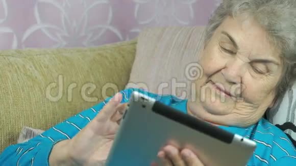 老年妇女在室内持有平板电脑视频的预览图
