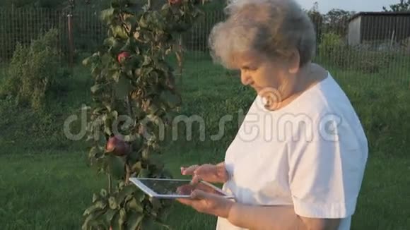 80多岁的老太太在户外拿着数码平板电脑视频的预览图