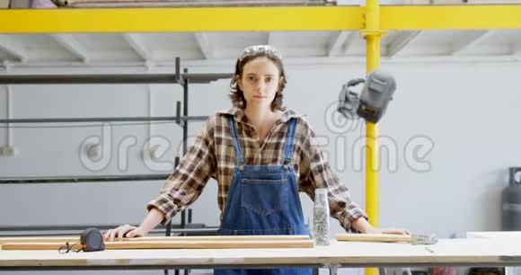 4k车间用木板站立的女焊工视频的预览图