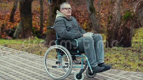 坐轮椅的残疾人在户外呼吸新鲜空气视频的预览图