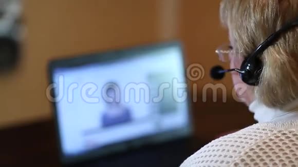 戴着耳机的女人通过电脑与顾客交谈视频的预览图