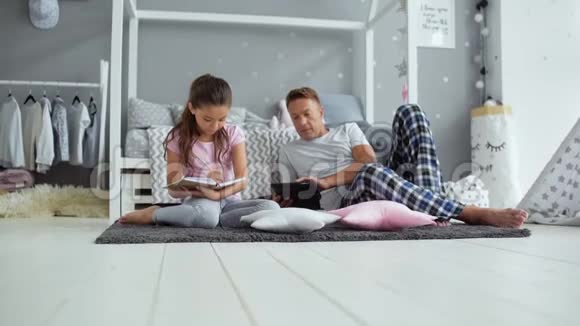 积极的父亲和小女儿一起在家休息视频的预览图