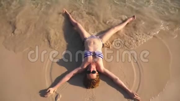 金发女孩穿着泳衣和黑色太阳镜在海边的白色沙滩度假漂亮的模特视频的预览图