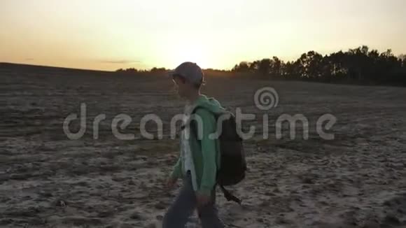 带背包的男孩在日落时在户外散步旅行理念视频的预览图