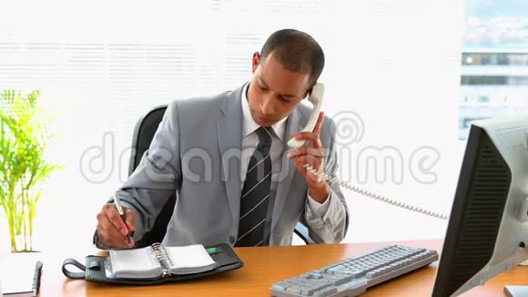 商人在办公桌前工作写日记视频的预览图