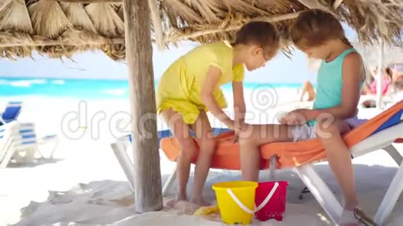 可爱的小女孩在海滩度假玩玩具孩子们玩沙子和沙滩玩具视频的预览图