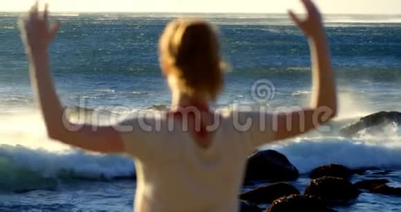 女子站在沙滩上双臂张开视频的预览图