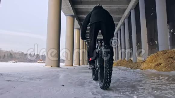专业的极限运动员骑着一辆肥胖的自行车在户外骑自行车的人在冬天骑在雪冰上男人是视频的预览图