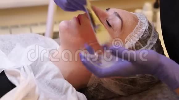 在面部病人上涂上化妆品凝胶视频的预览图