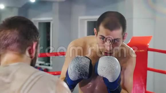 在健身房进行拳击训练两名男子在拳击场上进行拳击训练视频的预览图