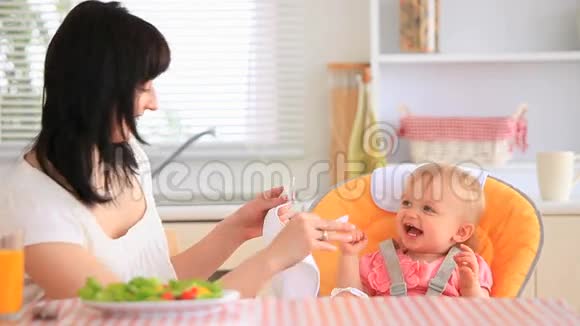 年轻的母亲喂养她的女儿视频的预览图