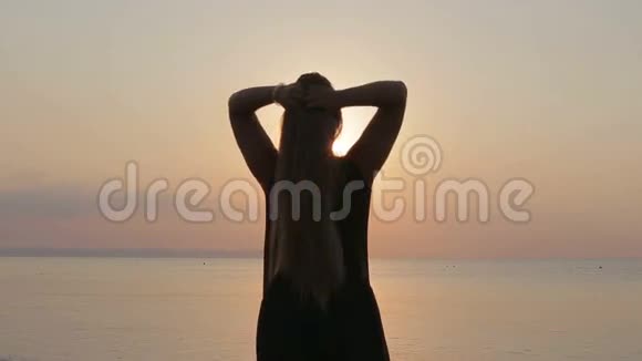 日落时欣赏大海的美丽女孩视频的预览图