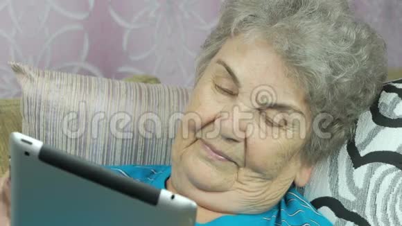 老年妇女在室内持有平板电脑视频的预览图