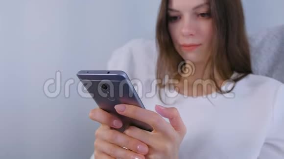 快乐的年轻黑发女人在手机上键入一条信息视频的预览图