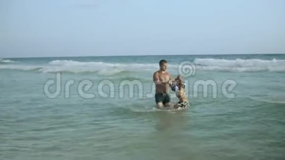 年轻的父亲和他的小儿子在海里玩得很开心视频的预览图