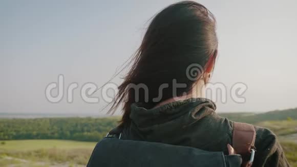 日落时分年轻的徒步旅行者女孩背着背包在山顶上生活方式旅行理念视频的预览图