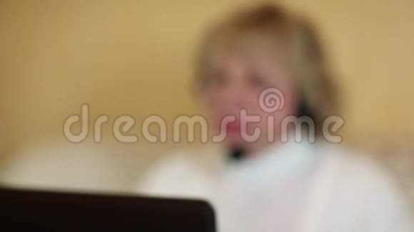 带着耳机的女人在电脑上和顾客交谈视频的预览图
