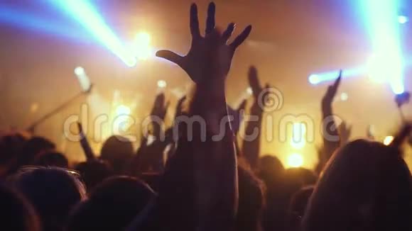 歌迷们在夜总会慢动作地在一场摇滚音乐会上挥手致意1920x1080视频的预览图