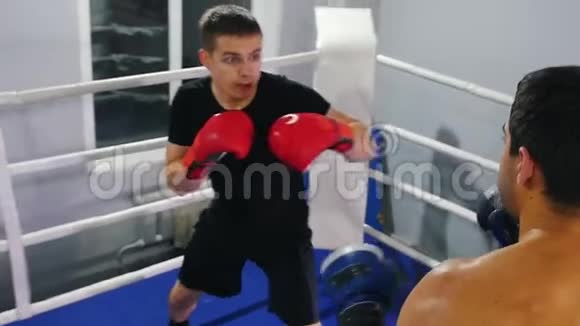 室内拳击两名男子在拳击场上进行训练视频的预览图
