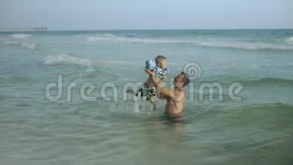 年轻的父亲和他的小儿子在海里玩得很开心视频的预览图