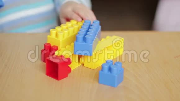 坐在桌子旁的彩色积木里玩耍的小男孩视频的预览图