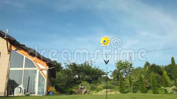 黄色风车在木屋前随风旋转视频的预览图