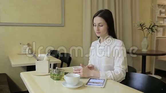 女青年在咖啡馆打电话视频的预览图
