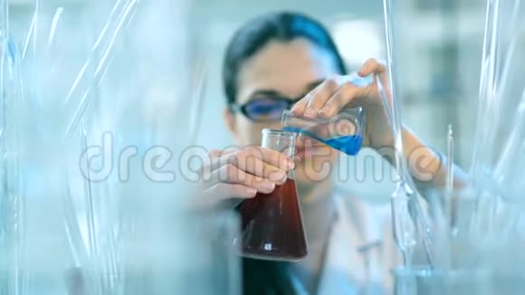 在实验室里拿着瓶子工作的女人视频的预览图