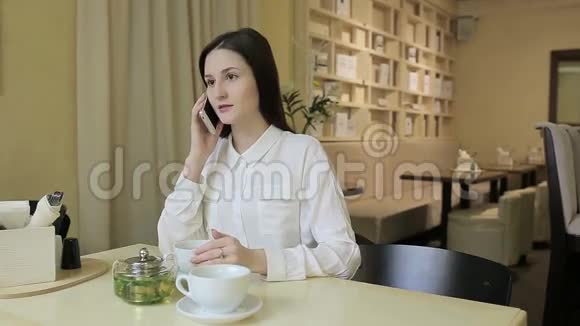 女青年在咖啡馆打电话视频的预览图