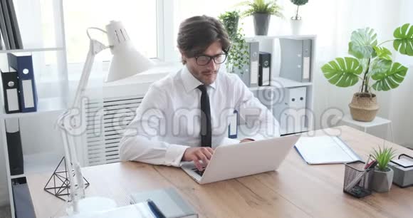在办公室笔记本电脑上工作的商人视频的预览图