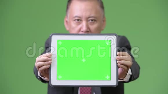 成熟的日本商人展示数字平板电脑视频的预览图
