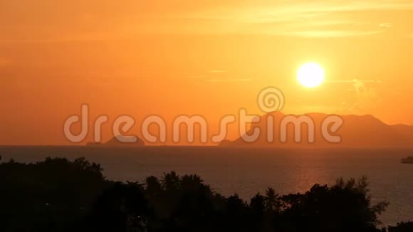 雄伟的热带橙色夏季夕阳在海面上群山的轮廓戏剧性黄昏的空中景色视频的预览图