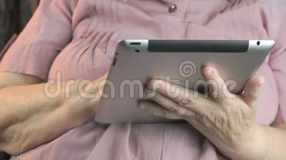 80多岁的老妇人手持银制平板电脑视频的预览图
